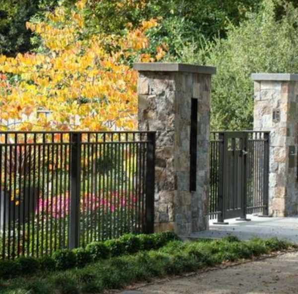 Pagar besi dengan aksen pilar batu yang mewah